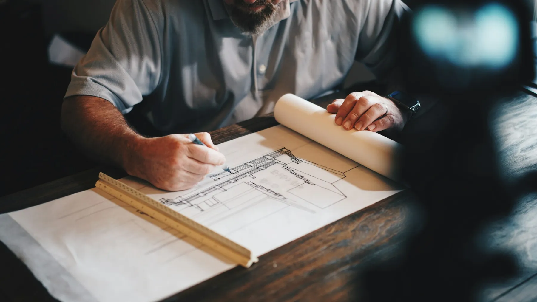 Development manager sketching building plans with a scale rule
